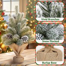 Load image into Gallery viewer, Decorative Christmas tree with snow-flocked branches and burlap base, surrounded by blurred festive lights.